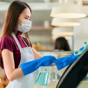 attractive-positive-young-asian-woman-staff-uniform-apron-spraying-detergent-alcohol-counter-product-cabinet-wiping-it-with-soft-cloth-when-disinfecting-cafe-ther-morning-safe-clean